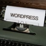 Close-up of a vintage typewriter with 'WordPress' typed on white paper.